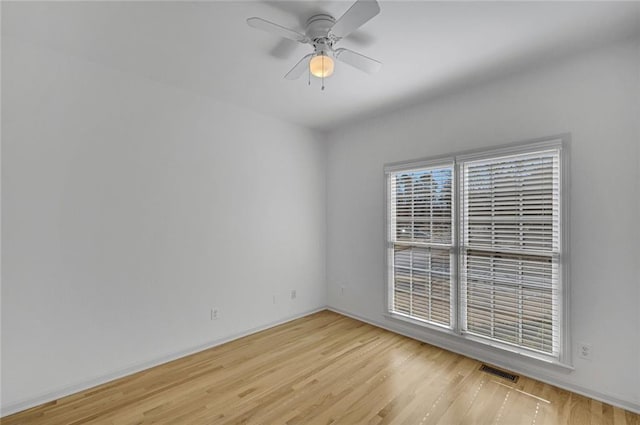 empty room with ceiling fan and light hardwood / wood-style flooring