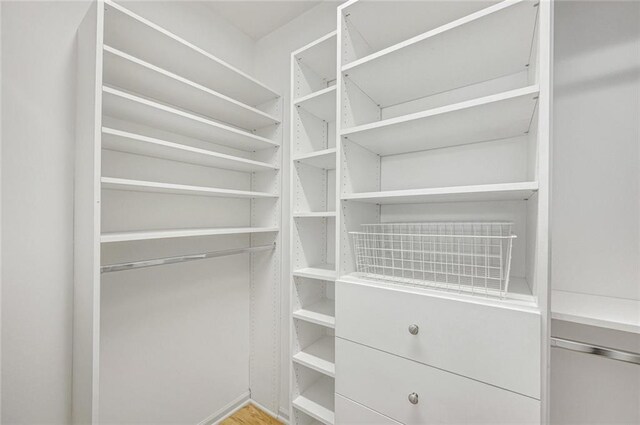 basement with a paneled ceiling and light hardwood / wood-style flooring