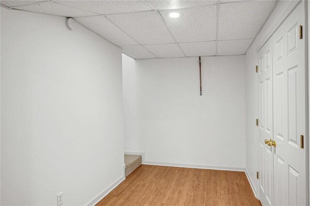 interior space featuring wood-type flooring and a drop ceiling