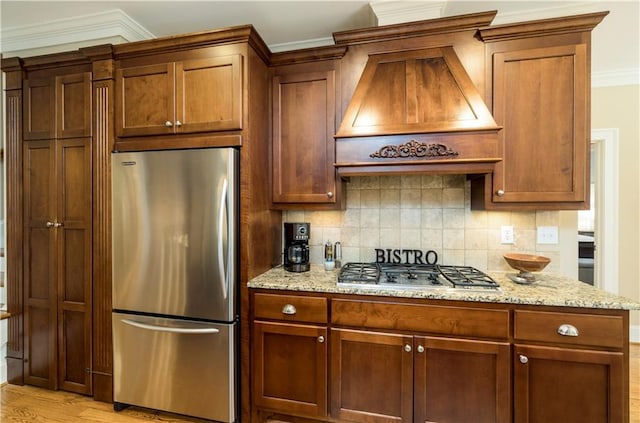 kitchen featuring premium range hood, appliances with stainless steel finishes, backsplash, and light stone counters