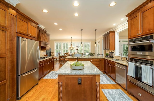 kitchen with a kitchen island, pendant lighting, sink, kitchen peninsula, and stainless steel appliances