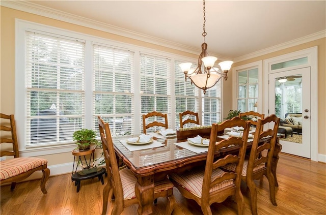 dining room with ornamental molding, a chandelier, and light wood-type flooring