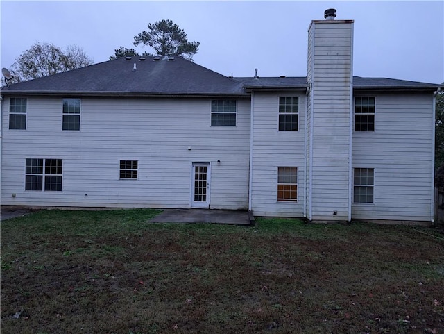 rear view of property with a yard and a patio