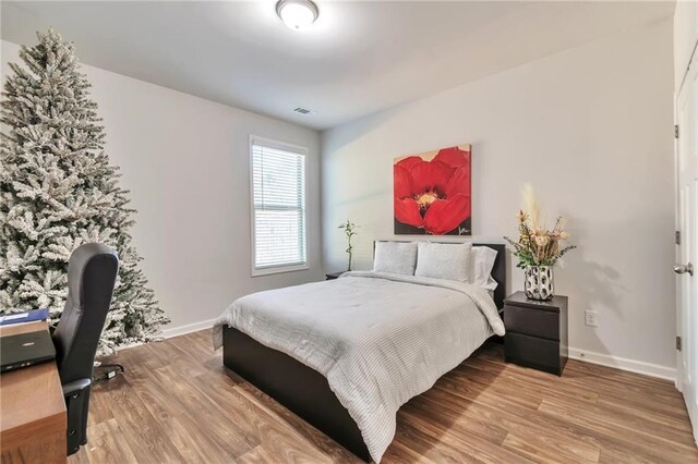 2021 Adam Acres Dr, Lawrenceville, GA 30043 - bedroom featuring visible vents, baseboards, and wood finished floors