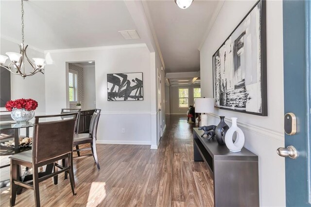 2021 Adam Acres Dr, Lawrenceville, GA 30043 - dining space with crown molding, an inviting chandelier, visible vents, wood finished floors, and baseboards