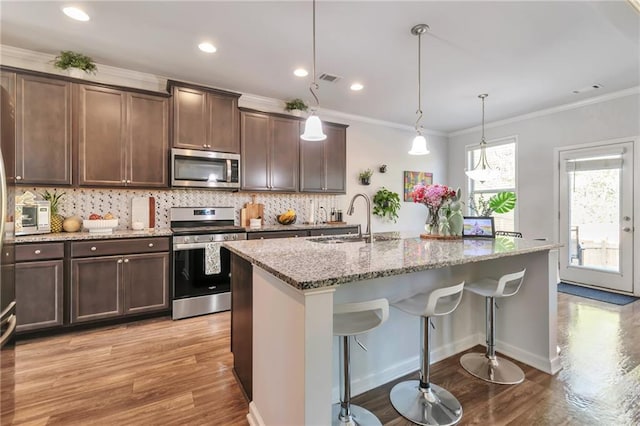2021 Adam Acres Dr, Lawrenceville, GA 30043 - kitchen featuring a sink, crown molding, stainless steel appliances, decorative backsplash, and light stone counters