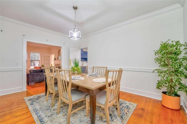 dining area featuring hardwood / wood-style flooring and ornamental molding