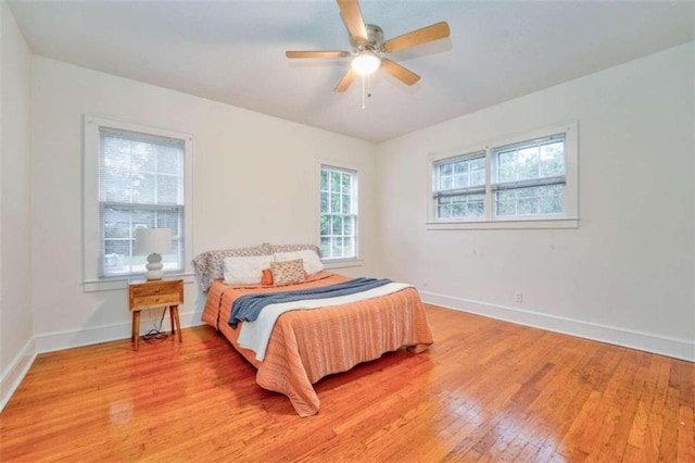 bedroom featuring multiple windows, ceiling fan, and light wood-type flooring