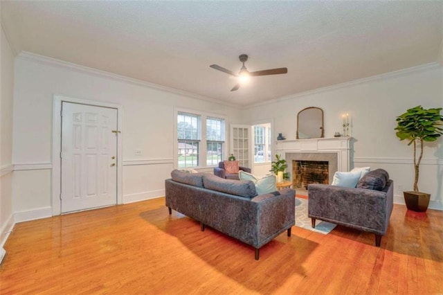 living room with hardwood / wood-style flooring, ceiling fan, and crown molding