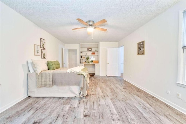 bedroom with ceiling fan, a textured ceiling, and light hardwood / wood-style flooring