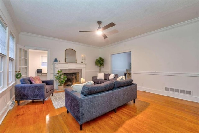 living room featuring crown molding, ceiling fan, and hardwood / wood-style flooring