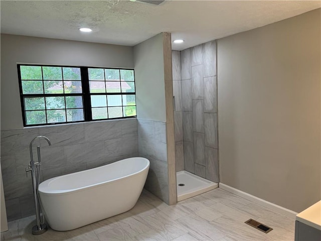 1516 Chase Ct, Riverdale, GA 30296 - full bath featuring a freestanding bath, marble finish flooring, a textured ceiling, recessed lighting, and a tile shower