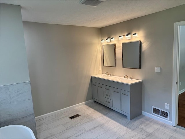 1516 Chase Ct, Riverdale, GA 30296 - bathroom with double vanity, a freestanding tub, and a textured ceiling