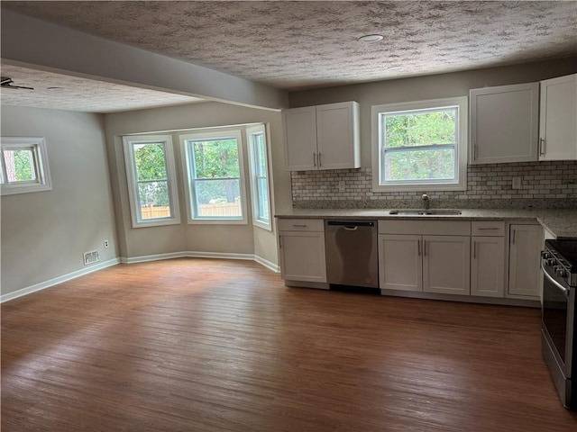 1516 Chase Ct, Riverdale, GA 30296 - kitchen with stainless steel appliances, wood finished floors, tasteful backsplash, plenty of natural light, and a textured ceiling