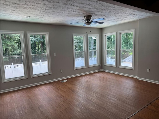 1516 Chase Ct, Riverdale, GA 30296 - spare room with ceiling fan, dark wood-style flooring, plenty of natural light, and a textured ceiling