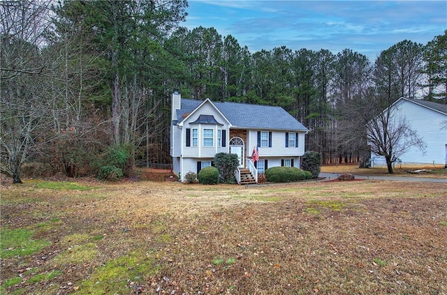 raised ranch featuring a front lawn