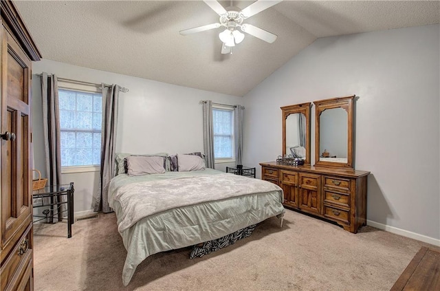 carpeted bedroom featuring multiple windows, a textured ceiling, vaulted ceiling, and ceiling fan