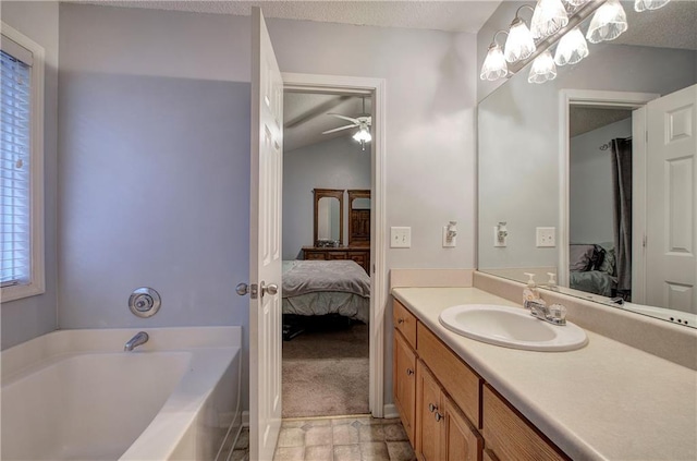 bathroom with vanity, a textured ceiling, and a tub to relax in