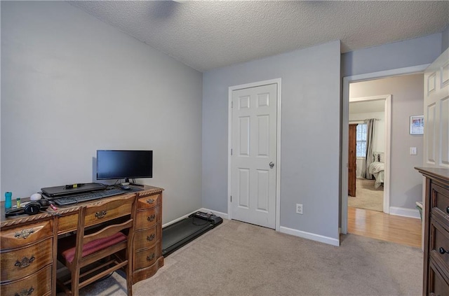 carpeted office with a textured ceiling