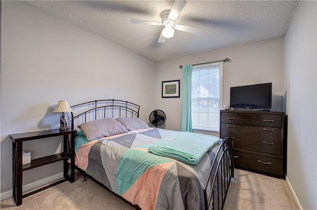 bedroom with light colored carpet, a textured ceiling, and ceiling fan