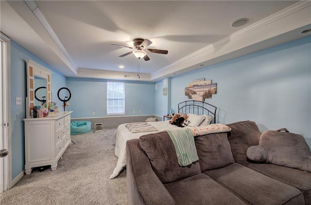 bedroom with light carpet, a tray ceiling, ornamental molding, and ceiling fan