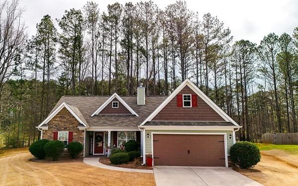 craftsman-style home featuring driveway and a chimney