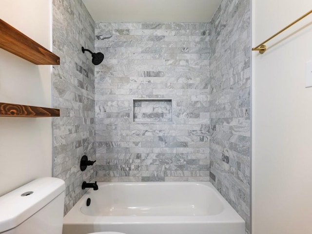 bathroom with tiled shower / bath combo and toilet