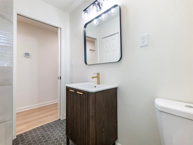 bathroom with hardwood / wood-style flooring, vanity, and toilet