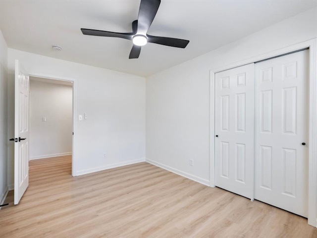 unfurnished bedroom with light hardwood / wood-style floors, a closet, and ceiling fan