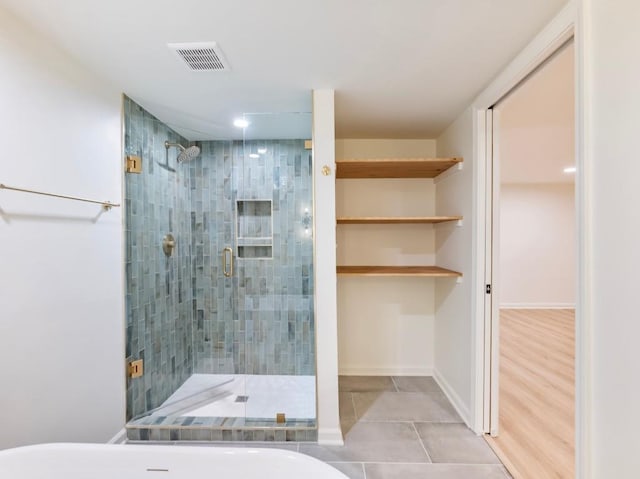 bathroom featuring tile patterned flooring and a shower with shower door