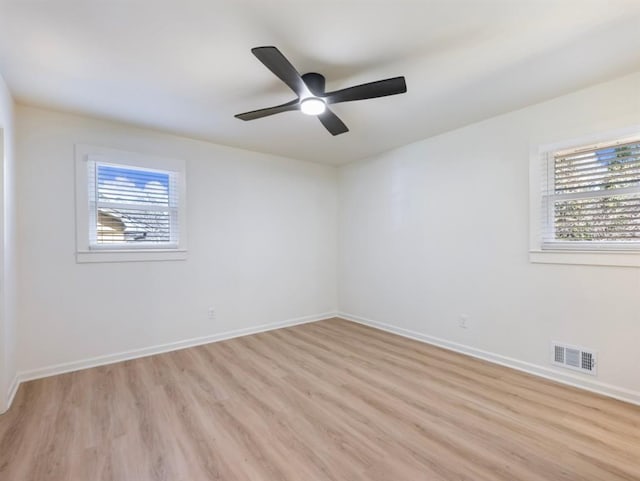 unfurnished room featuring ceiling fan, a wealth of natural light, and light hardwood / wood-style floors