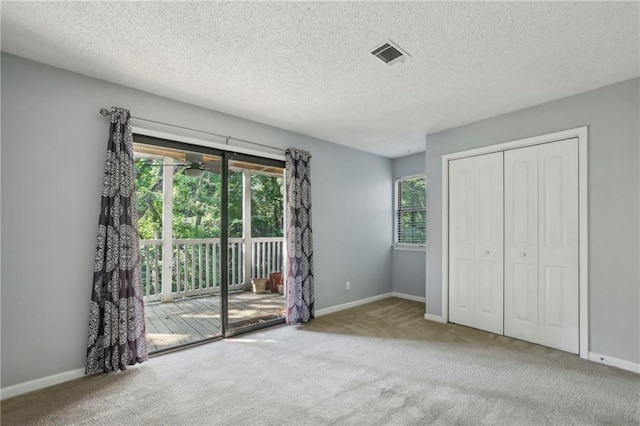 511 Barrington Hills Dr, Atlanta, GA 30350 - unfurnished bedroom featuring access to outside, carpet floors, a textured ceiling, and a closet