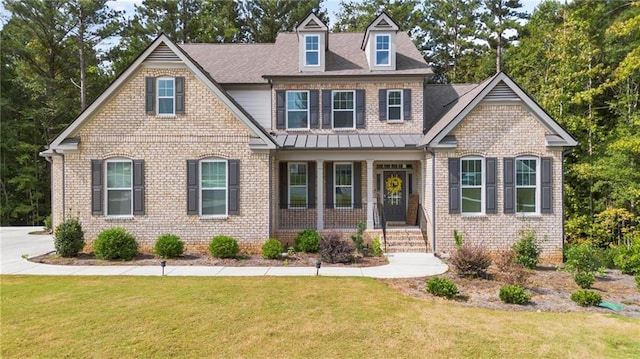 view of front of property featuring covered porch and a front lawn