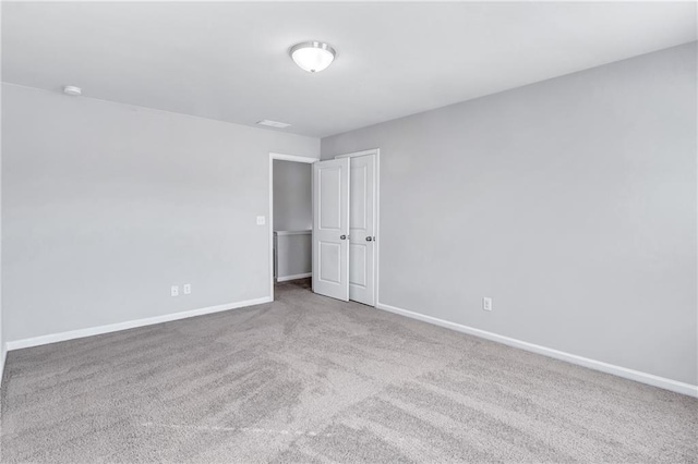 unfurnished bedroom featuring light carpet and baseboards