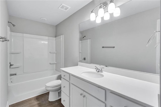 full bathroom featuring toilet, wood finished floors, vanity, visible vents, and washtub / shower combination