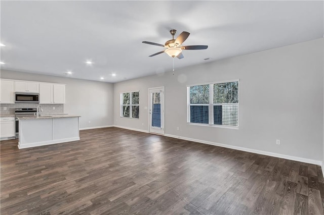 unfurnished living room with dark wood-style floors, ceiling fan, baseboards, and recessed lighting