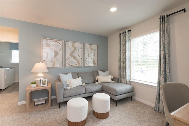 carpeted living room featuring washer and clothes dryer