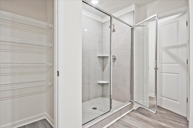 bathroom featuring hardwood / wood-style flooring and walk in shower