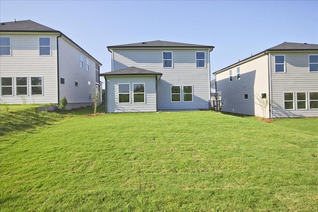 rear view of house featuring a yard