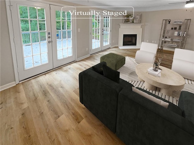 living room featuring french doors, ceiling fan, and light hardwood / wood-style flooring