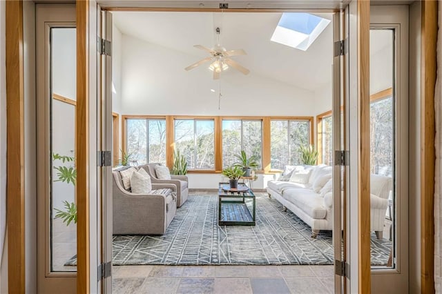 sunroom / solarium with ceiling fan and vaulted ceiling with skylight