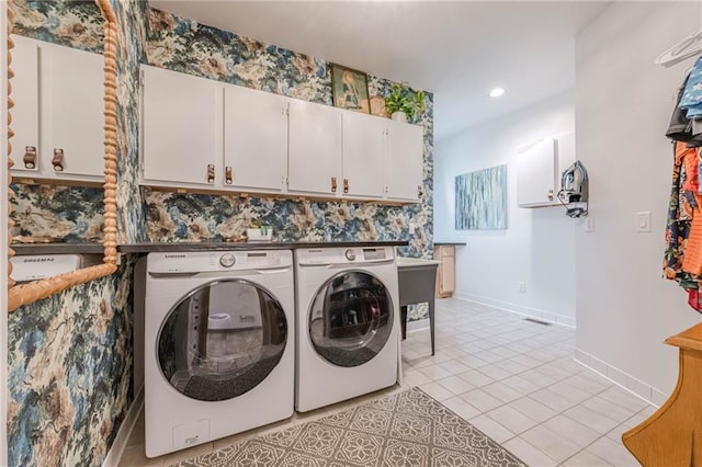 clothes washing area featuring washing machine and dryer, cabinets, and light tile patterned floors