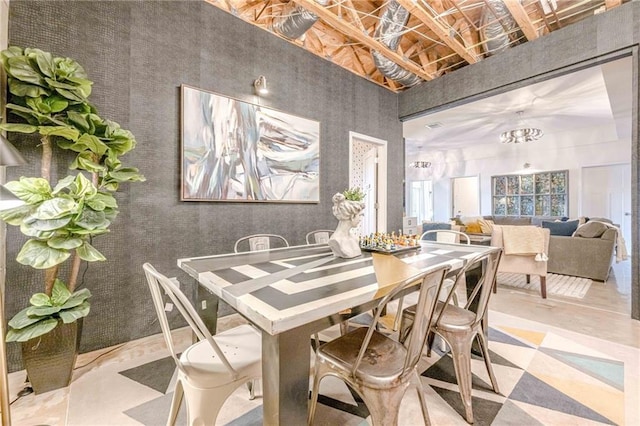 dining room featuring a chandelier and a towering ceiling