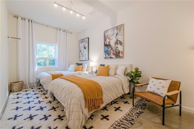 bedroom with light carpet and track lighting