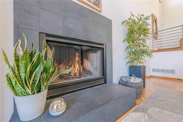 details featuring a tiled fireplace and wood-type flooring