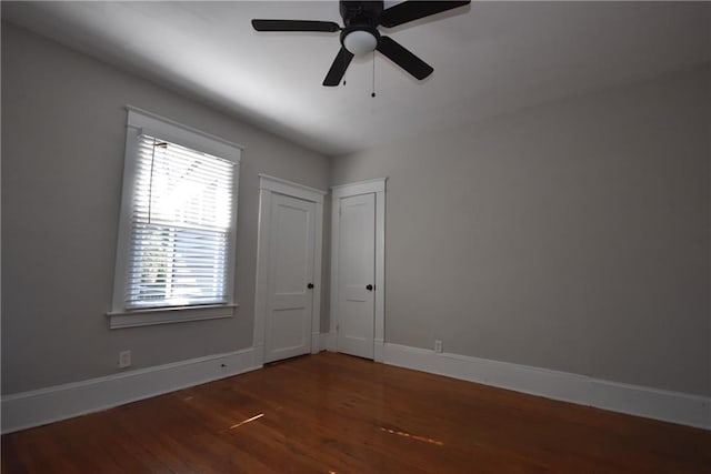 unfurnished room with dark wood-type flooring and ceiling fan