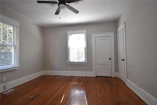 spare room featuring ceiling fan, dark hardwood / wood-style floors, and a wealth of natural light