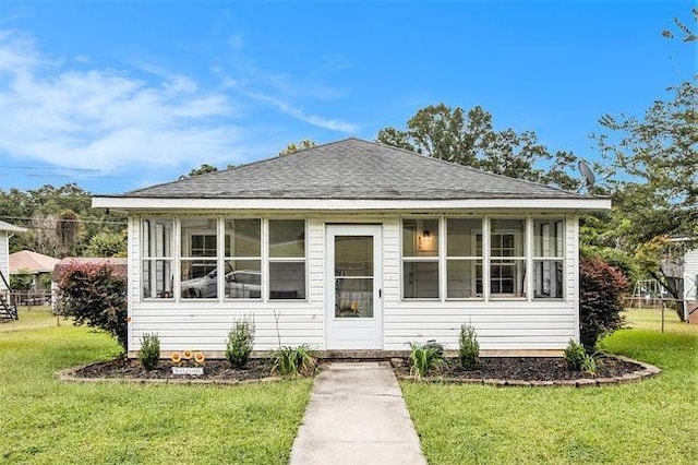 view of front facade featuring a front lawn and a sunroom