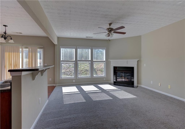 922 Gardenia Curv, Canton, GA 30114 - unfurnished living room featuring visible vents, baseboards, ceiling fan with notable chandelier, carpet flooring, and a glass covered fireplace