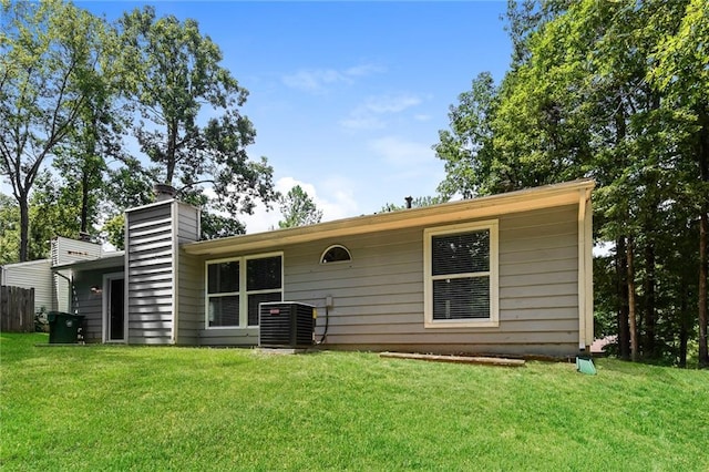 rear view of house with a yard and cooling unit